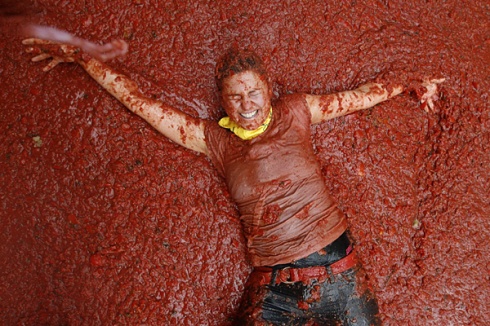 A girl plays with tomato pulp during the annual Tomatina tomato fight fiesta.